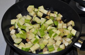 Добавляем в эту сковороду кабачки, нарезанные такими же кубиками, вместе обжариваем оба овоща 4-5 минут.
