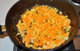 Сначала мелко шинкуем луковицу и на мелкой терке натираем морковь. Хорошо разогрев масло, на среднем огне 12-15 минут пассеруем овощи, периодически помешивая. Выкладываем и даем немного остыть.