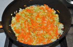 Морковь натираем на терке, добавляем к луку, обжариваем еще 3-4 минуты.