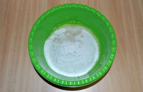 Упаковку крупной соли высыпаем в миску, добавляем свежий яичный белок и 2 ст. ложки воды. Вымешиваем соль до однородности, она должна стать немного влажной, похожей на морской песок. Примерно треть соли высыпаем на противень, застланный пекарской бумагой, слоем в 18-20 мм.