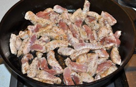 Растительное масло для  перекаливания  ставим в сковороде на сильный огонь. Через 4-5 минут выкладываем мясо, перемешивая и переворачивая, обжариваем пару минут, пока свинина меняет цвет на светлый. 