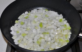 Нарезаем овощи: мелко – лук, соломкой – капусту, на терке - морковь, рубим зелень. В сковороде разогреваем масло, высыпаем лук и, помешивая,  пассеруем  5-7 минут на среднем огне.