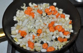 Крупным кубиком нарезанные луковицы, нетонкие кружки моркови и порубленные черешки сельдерея обжариваем 3-4 минуты в той же сковороде при помешивании.