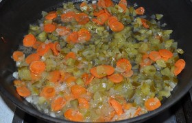 Лук и морковь на маленьком огне обжариваем... нет, не так - томим в столовой ложке растительного масла до золотистого цвета. (Как правильно делать  карамелизацию , чтобы суп получился вкусный - прочитайте). Дождавшись, когда лук и морковь станут почти мягкими, добавляем измельченные огурцы, рассол и тушим 5-8 минут под крышкой.  