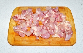 Мясо, снятое с куриных бедрышек, нарезаем небольшими кусочками.