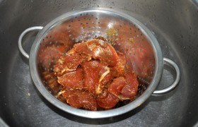Перед жаркой перекладываем мясо в сито или дуршлаг – пусть сольется маринад.