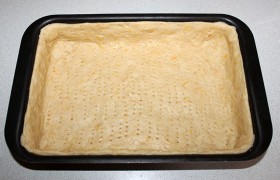 Смазав стенки и дно растительным или сливочным маслом, выкладываем в форму тесто. Часто-часто накалываем вилкой и на 10 минут ставим в середину духовки, предварительно включенной на 200°.