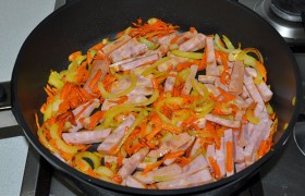 Кладем нарезанную дольками или кубиками колбасу, смешиваем с овощами, жарим 3-4 минуты.