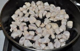 На другой сковороде, просторной, 4-5 минут  перекаливаем  2-3 ст. ложки масла. Выкладываем филе, перемешивая, жарим примерно 2 минуты – достаточно, чтобы кубики филе стали белыми. Солим и перчим. 