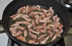 За это время (4-5 мин.) в сковороде на сильном огне  перекаливается  новая порция масла – 2-3 ст. ложки. Закладываем свинину, непрестанно помешивая и переворачивая лопаткой, быстро, за 2-3 минуты, обжариваем мясо до изменения цвета и корочек.