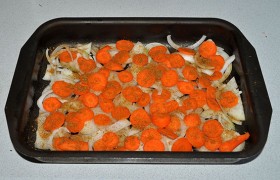 Нарезаем лук полукольцами, морковь – нетолстыми кружками. Форму для запекания промазываем маслом, дно укрываем луком и морковью, приправляем.