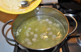 У нас обычно заранее приготовленные фрикадельки лежат в морозилке, так что времени на суп уходит и того меньше. Свежие или замороженные, фрикадельки мы опускаем в воду, когда она закипела, а бульонный кубик уже растворяется в ней. И начинаем, отщипывая ложечкой тесто, опускать  клецки  в суп. 