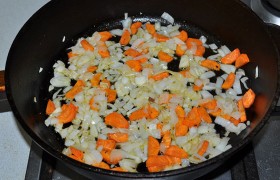 А в сковороду, огонь под которой мы перевели на средний, засыпаем нашинкованные морковь с луком,  пассеруем  6-8 минут. 
