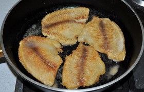 Увеличиваем огонь почти до сильного,  ставим тяжелую сковороду, наливаем масло. Пока оно  перекаливается , тщательно панируем в муке филе тилапии. И жарим до корочки в общей сложности 5-6 минут. Подаем тилапию, добавив приготовленный соус, который делает вкус рыбы богатым и ярким.