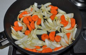 На той же сковороде, снизив огонь,  пассеруем  нарезанные крупными дольками луковицы и довольно толстые кружки моркови (или половинки).