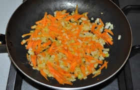 Для суповой заправки порубленный лук пассеруем до прозрачности на разогретом масле (средний огонь), 5-6 минут. Засыпаем тертую морковь, продолжаем пассеровку, иногда помешивая, 4-5 минут.
