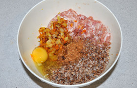 К мясному фаршу добавляем сваренную гречку, лук с морковью, приправы, вбиваем яйцо. 

