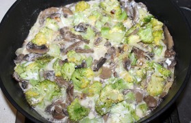 В сковороду выкладываем брокколи. Полстакана (или побольше) отвара брокколи смешиваем со сметаной, заливаем большую часть в сковороду, перемешиваем капусту с грибами, солим и перчим.