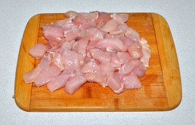 Куриные филе нарезаем поперек волокон ломтиками толщиной около 12-15 мм, затем – на брусочки. Перчим по вкусу.