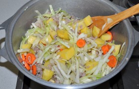 Шинкуем капусту, нарезаем картофель, морковь и корень петрушки, добавляем к фаршу, заливаем немного воды, заправляем солью и перцем-горошком и оставляем на 20-25 минут  тушиться  под крышкой до готовности.