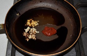 Одновременно готовим соус во второй сковороде, поставив на огонь, но без масла. Измельчаем имбирь и чеснок, кладем аджику, вливаем мед и уксус, соевый соус, прогреваем, помешивая. 
