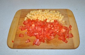 Терпеливо нарезаем помидор и сыр мелким кубиком и рубим зелень.