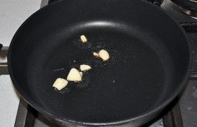 Ставим на средний огонь сковороду, в которую наливаем немного масла. Раздавливаем чесночные дольки плоскостью ножа и обжариваем за 40-60 секунд до коричневой корочки.