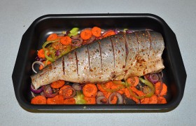 Когда духовка разогрелась до 190-200°, овощи выкладываем на дно формы, сбрызгиваем маслом, на эту овощную подушку – горбушу. Ставим на средний уровень духовки.