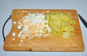 Остужаем отварные яйца и картофель в холодной воде. Нарезаем клубни мелким кубиком, как и яйца. Перекладываем в миску.