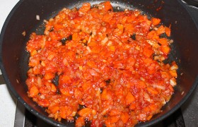 Засыпаем в сковороду нашинкованные средним кубиком морковь и лук, меняем огонь на средний, даем корнеплодам потомиться 9-10 минут. Кладем травы (любой набор по вкусу, это может быть  хмели-сунели , приправа к мясу и т.п.). 