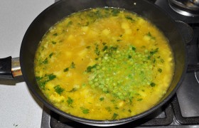 Далее мы вливаем в сковороду овощной бульон, закладываем нарезанный перец чили, соль, доводим до кипения. Уменьшаем огонь, и под крышкой наш суп варится еще минут 20. За 5 минут до окончания варки всыпаем зеленый горошек, при желании - добавляем еще кинзы.