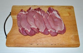 Промытый и очень хорошо обсушенный кусок свинины нарезаем ломтями 12-15 мм толщины. 