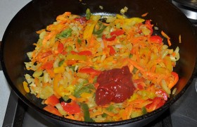 Когда лук станет прозрачным, добавляем нарезанный сладкий перец, держим на огне еще 4-5 минут. Кладем томатную пасту, кетчуп и посыпаем мукой.