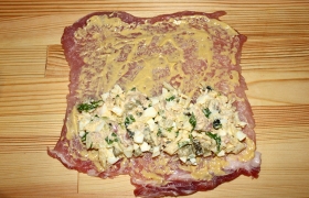 На каждый пласт мяса наносим по всей поверхности дижонскую горчицу, на нее – начинку, примерно на половину площади. 
