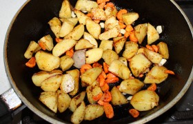 Нарезанный довольно крупно картофель, добавив немного масла, обжариваем на том же огне 12-13 минут. В середине процесса подсыпаем кусочки моркови,