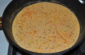 А в сковороде 5-6 минут обжариваем нашинкованный лук и тертую морковь, смешиваем с томатной пастой и сметаной, посыпаем кориандром, подливаем горячей воды (примерно стакан).