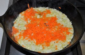 Небольшим кубиком шинкуем лук. Разогреваем растительное масло и на среднем огне пассеруем лук, помешивая, 5-6 минут. Добавляем натертую морковь, продолжаем пассеровку овощей 3-4 минуты.