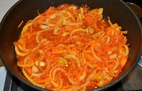 Добавляем немного масла и пассеруем на среднем огне нашинкованный средним кубиком лук и тертую крупно морковь, 7-8 минут. Добавляем томатную пасту, сахар, соль, перец, стакан воды, тушим 2-3 минуты. 