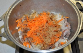 Добавляем тертую морковь, приправы, продолжаем помешивать. 