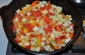 А на сковороду, разогрев еще немного масла на среднем огне, закладываем нарезанные некрупно помидоры, сладкие перцы, капусту, лук, дольки чеснока. Периодически перемешивая, тушим 4-6 минут. В середине тушения добавляем томатную пасту.