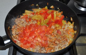 Когда весь фарш стал светлым – добавляем в сковороду нарезанные кубиком помидоры и сладкий перец. Тушим 4-5 минут.