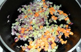 На сковороде, разогретой с маслом, на этом же среднем огне обжариваем 10-12 минут, периодически помешивая, нашинкованные овощи: лук, морковь, сельдерей и чеснок.