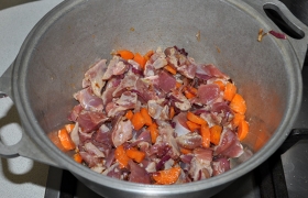 Небольшими кусочками нарезаем промытое мясо индейки. Закладываем мясо к овощам, помешиваем, пока оно за 3-4 минуты становится светлым.