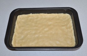 Минут через 30, когда тесто в морозилке основательно заморозится, а шар с полки – станет тверже от застывшего масла – начинаем сборку пирога. Делаем из шара лепешку, кладем в форму, разминаем до толщины меньше 10 мм. По краям делаем небольшие бортики.