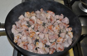 Вторую сковороду раскаляем с небольшим количеством масла, выкладываем кусочки мяса, обжариваем, помешивая, до первых корочек, 3-5 минут.