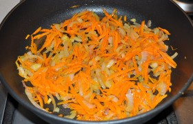 В это время пару ст. ложек масла разогреваем на среднем огне в сковороде,  пассеруем  5-6 минут нашинкованный половинками или четвертинками колец лук. Добавляем к нему тертую крупно морковь, продолжаем пассеровку 5-6 минут.