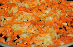А пока шинкуем средним кубиком лук, соломкой (или как захочется) морковь. Разогреваем масло на просторной сковороде, 3-5 минут, помешивая, обжариваем лук, засыпаем морковь, так же обжариваем еще 7-10 минут (средний огонь).