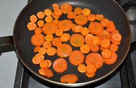 Морковь, нарезанную кружками,  пассеруем  минут 5-6 на масле, на среднем огне, и еще минут 5-6 тушим, добавив совсем немного воды в сковородку. Нарезаем кружками помидоры. Окуней приправляем перцем, солью, травами, внутрь кладем петрушку (или укроп). 
