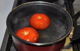 В это же время кладем надрезанные у плодоножки помидоры в кипяток. Через 1-2 минуты, когда кожица начинает сползать, быстро остужаем их, снимаем кожицу и нарезаем мелком кубиком.