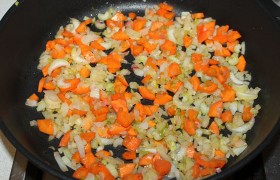 Разогреваем в двух сковородах, поставленных на средний огонь, растительное масло. В ту, что побольше, выкладываем лук, сельдерей, морковь. Томим на огне 10-12 минут ( карамелизуем ). 